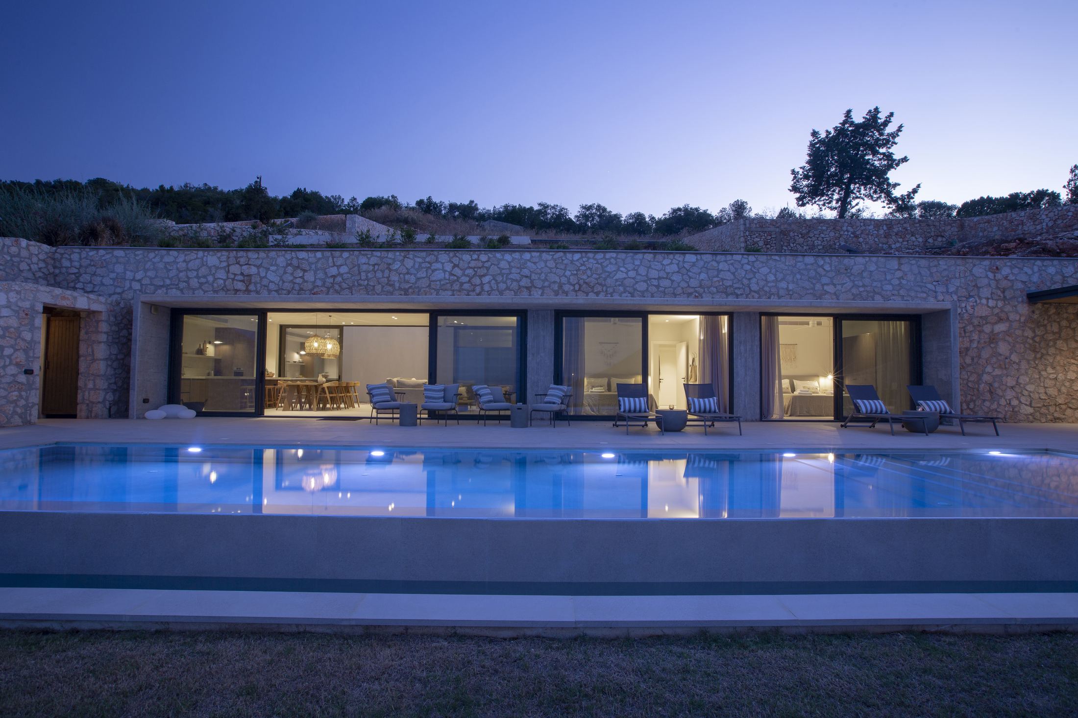 Villa Luma glowing at dusk over the infinity pool