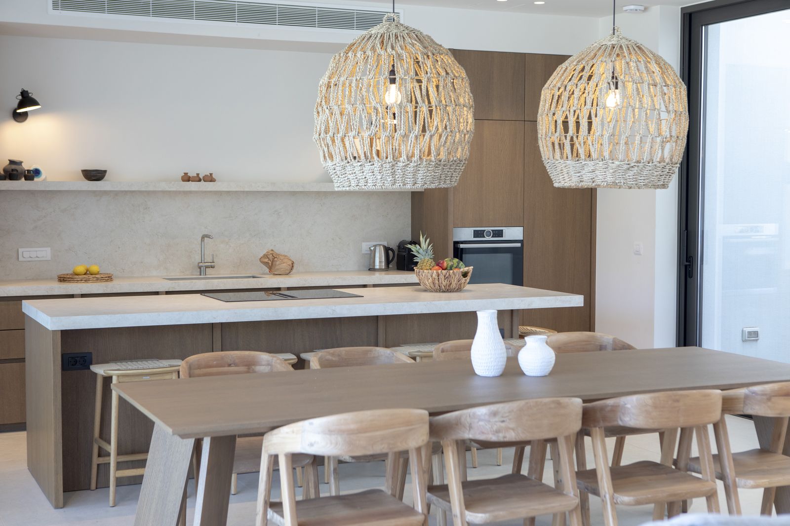 Open-plan kitchen and dining with rattan pendants