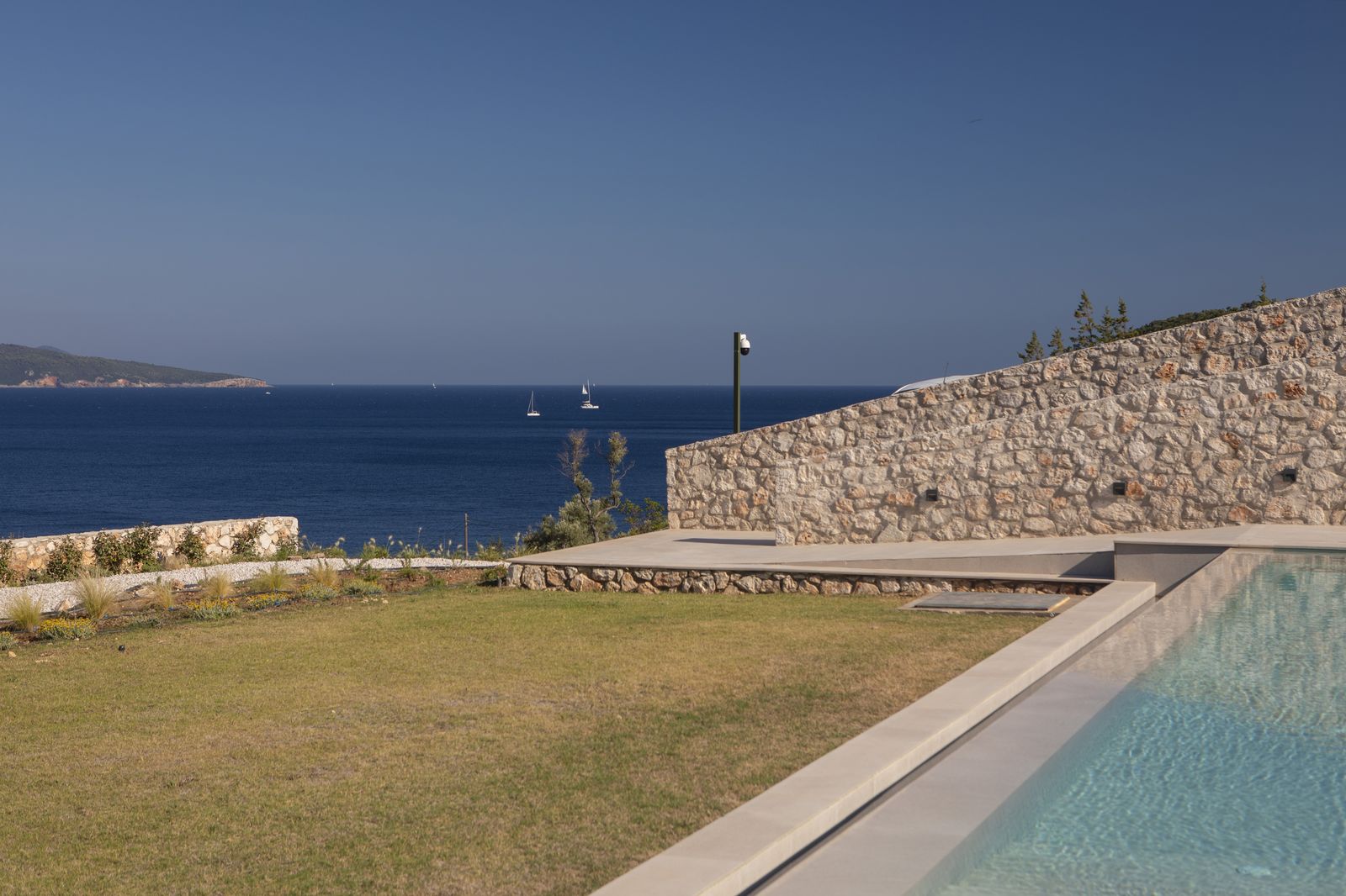 Manicured lawn beside the pool with open sea view