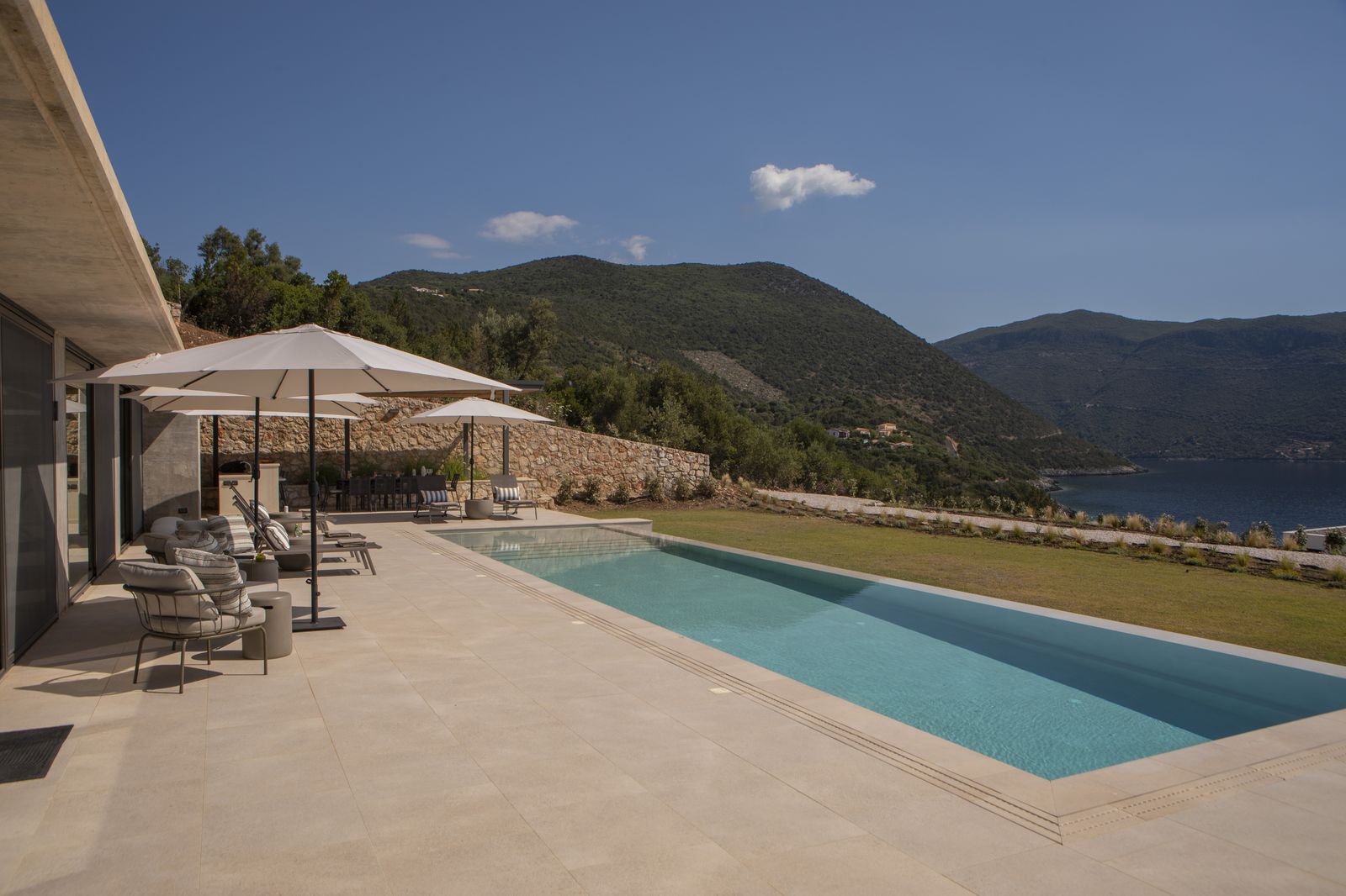 Infinity pool terrace sweeping toward Afteli Bay